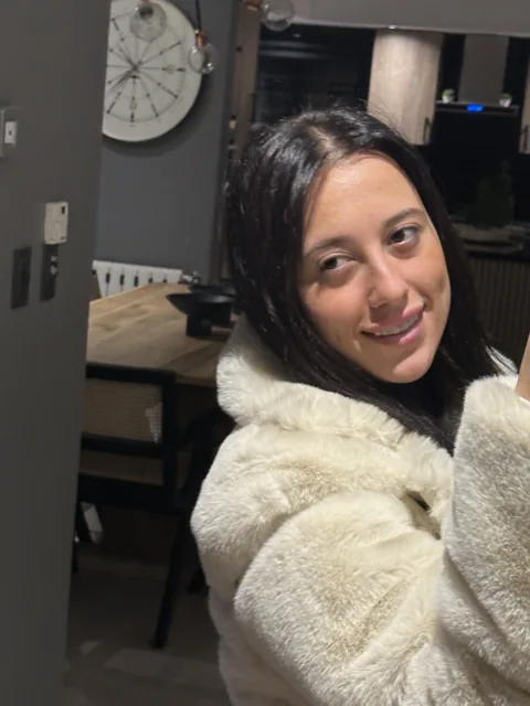 Natalye smiling in a soft cream jacket